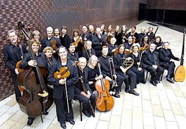 Photo of the Philharmonia Baroque Orchestra in formal attire with their instruments.